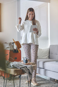 Portrait of young woman sitting on sofa at home