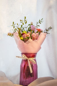 Close-up of woman holding red flowering plant