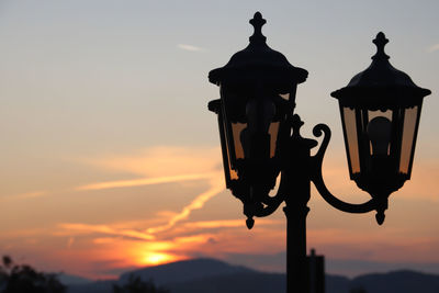 Low angle view of street light against sky at sunset