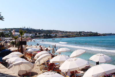 People on beach against clear sky