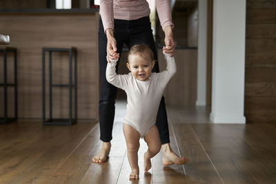 Cute baby boy with mother walking at home