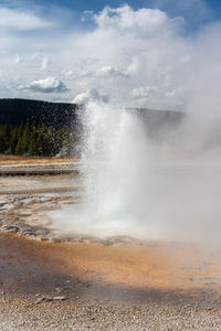 Geyser erupting in geyser basin in yellowstone national park