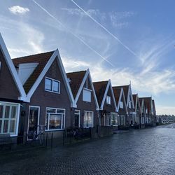 Panoramic view of buildings by river against sky