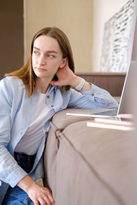 Portrait of young woman using laptop at home
