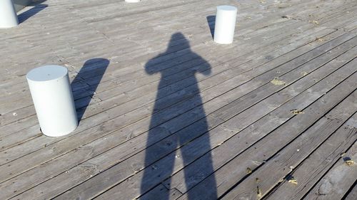 High angle view of people shadow on wooden floor