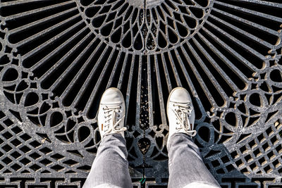 Low section of person standing on metal