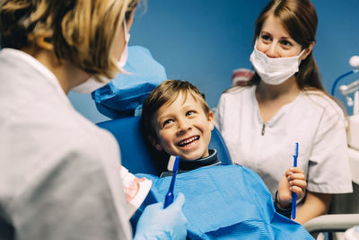 Cheerful patient looking at dentist in operating room