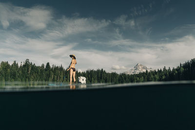 A young woman enjoys a standup paddle board on lost lake in oregon.