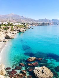 Panoramic view of sea and rocks against clear sky