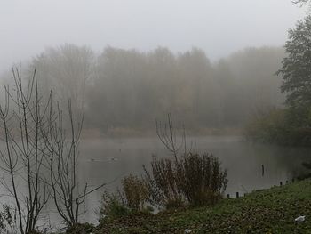 Scenic view of lake against sky during foggy weather