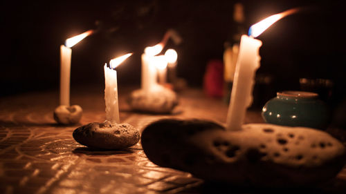 Illuminated candles on stones at night