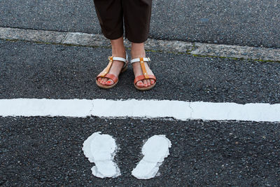 Low section of man standing on road