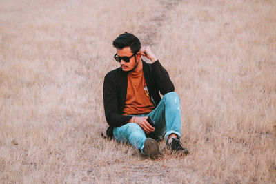 Young man sitting on field