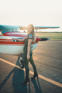 Full length of woman on airport runway against sky