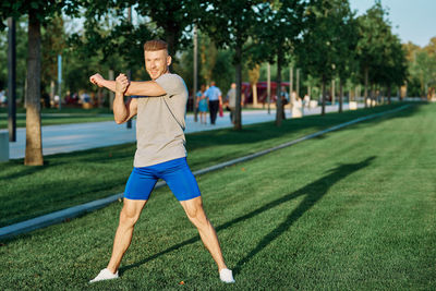 Full length of woman exercising on field