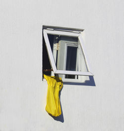 Yellow raincoat hanging out of a window