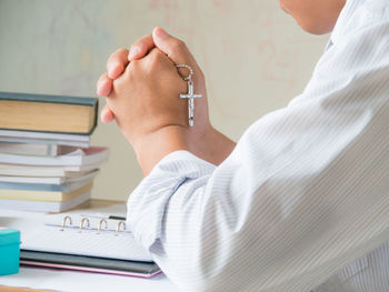 Midsection of man and woman reading book on table