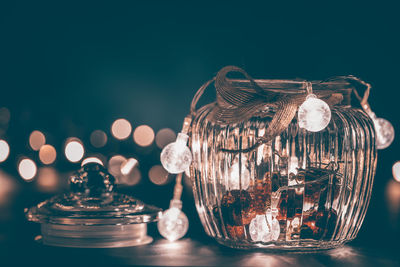 Illuminated light bulbs around glass jar