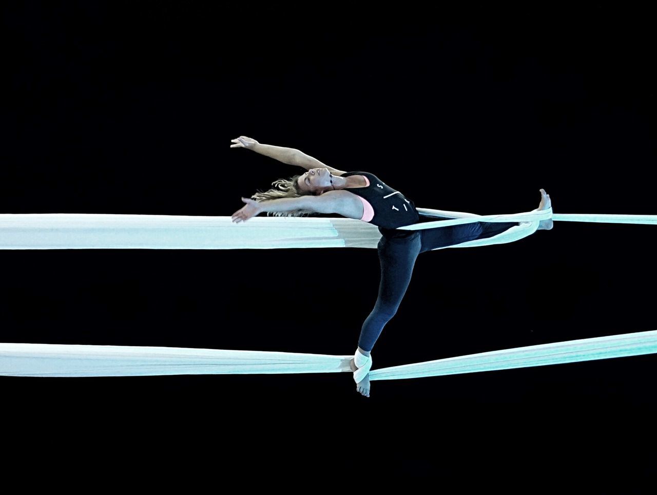 black background, skill, studio shot, performance, balance, full length, elegance, sport, indoors, leotard, flexibility, dancing, people, strength, agility, young adult, competitive sport, ballet, practicing, acrobat, gymnastics, effort, human arm, beautiful woman