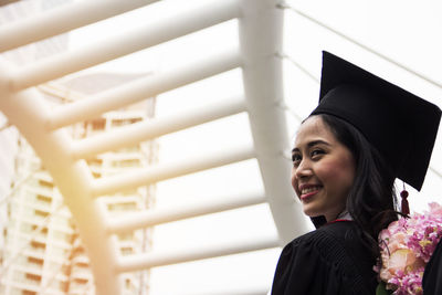 Smiling young woman in graduation gown