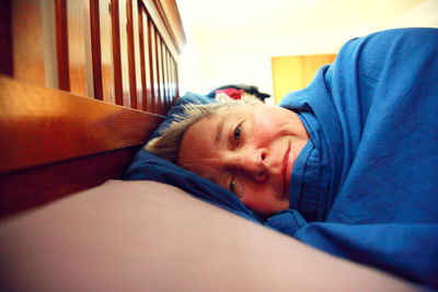 Portrait of smiling mature woman lying on bed