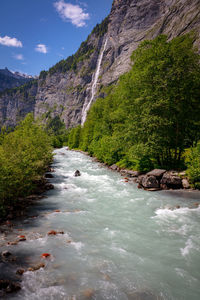 Scenic view of river amidst mountains against sky