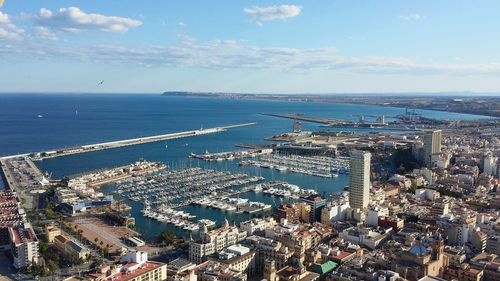 High angle view of buildings by harbor against sky in city
