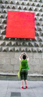 Rear view of boy standing on red road