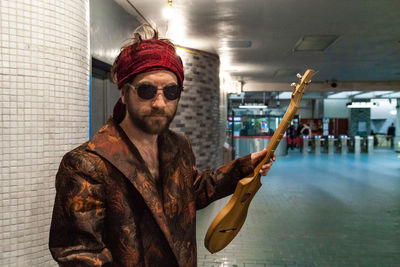 Man wearing sunglasses standing against ceiling