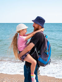 Rear view of mother with daughter on beach