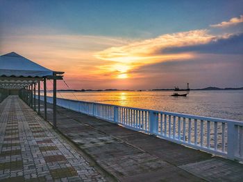 Pier over sea against sky during sunset