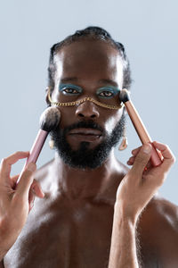 Close-up of young man with face paint against black background