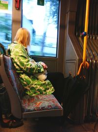 Rear view of woman sitting in train