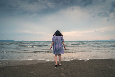 Rear view of man standing on beach