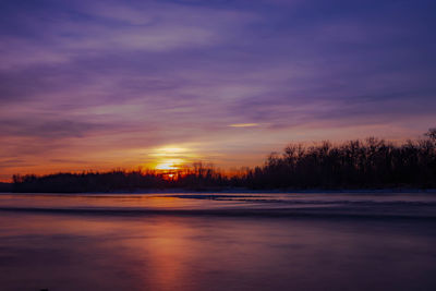 Scenic view of lake against romantic sky at sunset