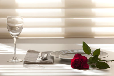 Close-up of rose in glass on table