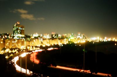 Illuminated cityscape against sky at night