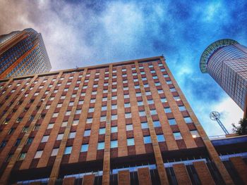 Low angle view of modern building against cloudy sky