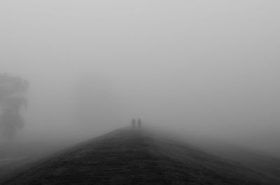 People on footpath against sky during winter