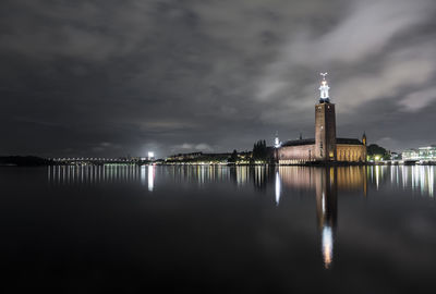 Reflection of lighthouse in water at night