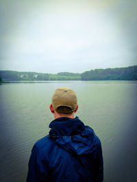 Rear view of man standing on riverbank