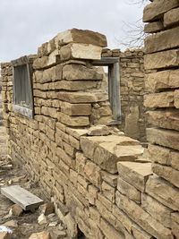 Low angle view of stone wall against building