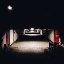 Illuminated tunnel at night