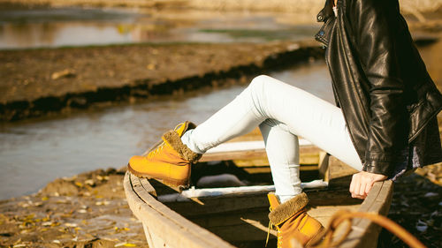 Low section of young woman sitting on boat