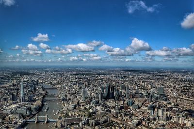 Aerial view of cityscape with thames river against sky