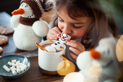 High angle view of girl holding food on table