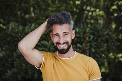 Portrait of smiling man standing against plants