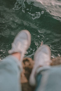 Low section of man in shoes at sea