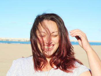 Close-up portrait of beautiful young woman against clear sky