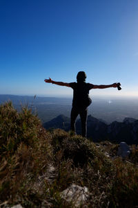 Full length of woman standing on mountain against sky